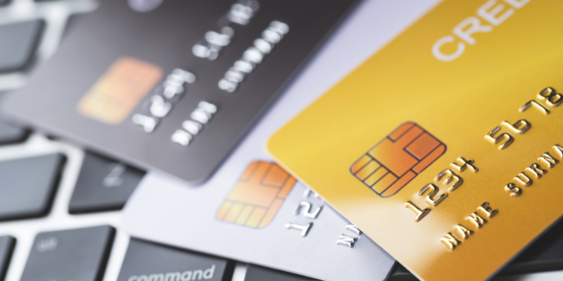 Multiple credit cards on a laptop keyboard.