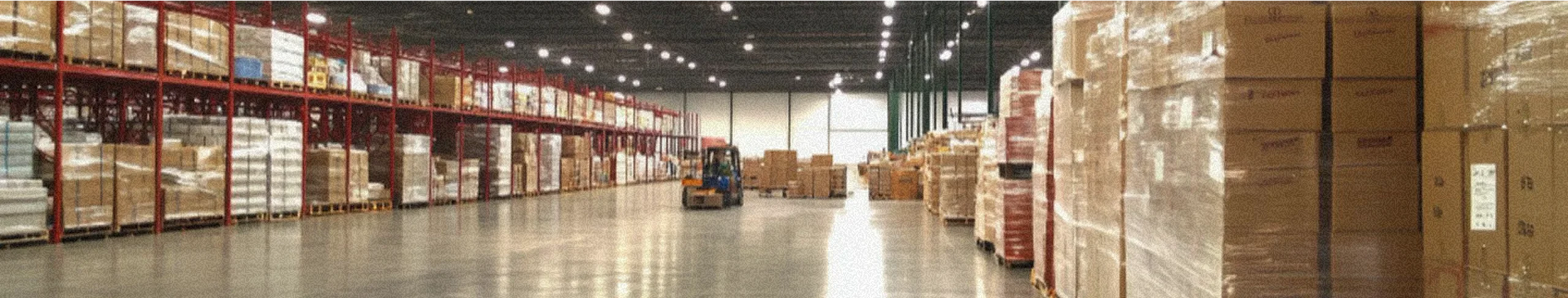 A wholesale factory with stacked boxes and a forklift.