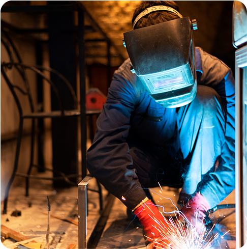 A welder welding with all the safety equipment.