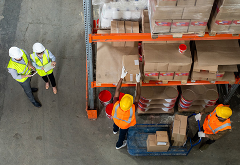 Four men loading and unloading goods from a top-angle view.